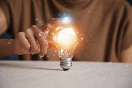 Hand holding light bulb. idea concept with innovation and inspirationの写真素材