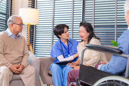 Depressed elderly female crying, young nurse consoling her at retirement home. Unhappy impaired man feeling lonely and sad.の写真素材