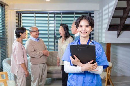 Young nurse in blue coat smiling looking at camera. Portrait of satisfied elderly patient and his caregiver. Medical care of older generation people, nursing conceptの写真素材