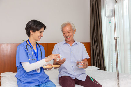 Senior man eats pills before lunch at retirement home.の写真素材
