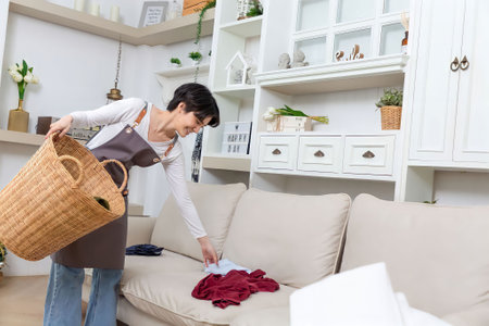 Happy Asian cleaner woman with laundry working at home.の写真素材