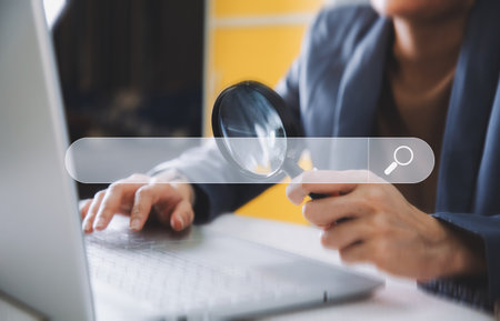 A business man holding magnifier and searching bar, technology and internet online concept.の写真素材