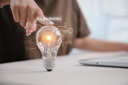 Hand holding light bulb with virtual graduate icon. E-learning education graduation concept, smart learning online with brainstorm concept.の写真素材