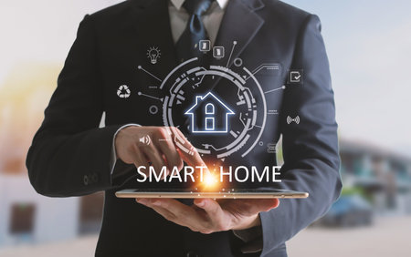 Hands using Smart home control on tablet. Interior of living room in the background.の写真素材