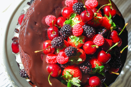 Black chocolate pie with strawberries raspberries cherriesの写真素材