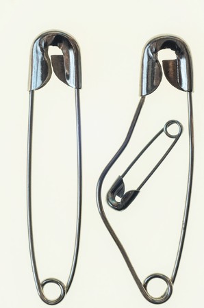 A family rapresented with three safety pins, pregnant mother and fatherの写真素材