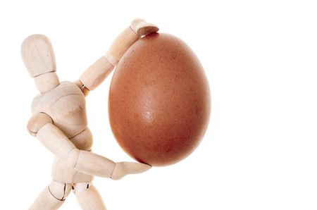 wooden dummy that carries with caution, a fragile fresh eggの写真素材