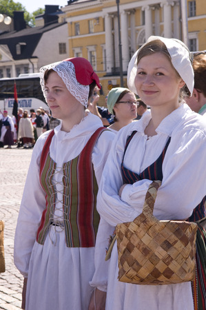 June 20, 2010. Helsinki, Finland. Two women wearing traditional clothes is taking part in the Traditional Culture Festival. One woman is carrying a birchbark basket.のeditorial素材