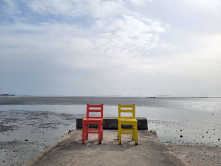 Vivid holiday chair with a tidal flat in the backgroundの写真素材