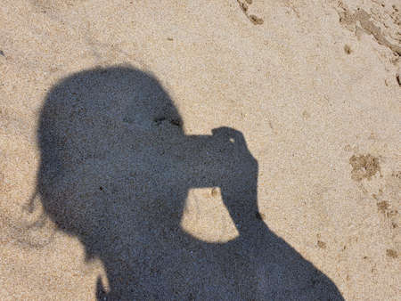 Shadow selfie on the sandy beachの写真素材
