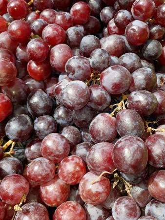 Bunches of fresh red grape on the counter at the marketの写真素材