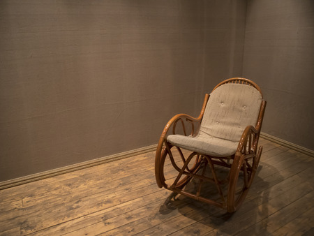 Wicker rocking chair in empty room with wooden floor, concept indoor compositionの写真素材