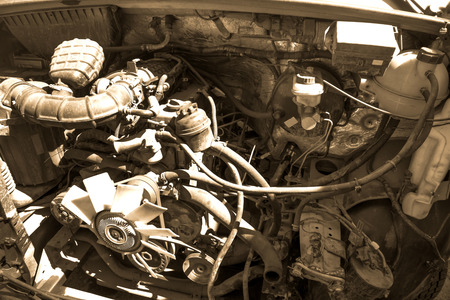 Old broken and dirty car car close up, view under the hood in sepia tonesの写真素材