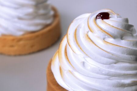 Cupcake with white whipped cream and red berry on the topの写真素材