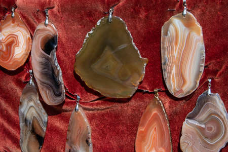 Few different beautiful flat polished agate pendants at the open air fairの写真素材