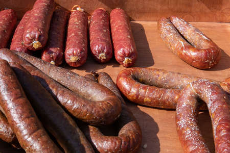 Few appetizing rustic homemade sausages lying at the village fair trade tentの写真素材