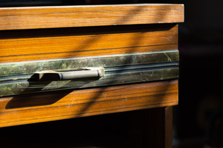 Closeup shot of old dusty wood drawer on hard natural light