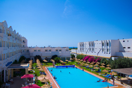White hotel building with a pool in summer in Tunisiaのeditorial素材