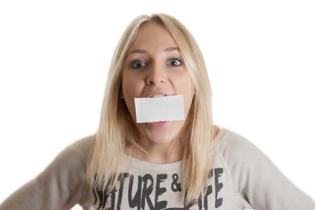 Girl with the business card in her mouth  isolated in whiteの写真素材
