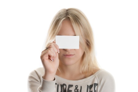Girl with the business card in her hand covering her eyes isolated in whiteの写真素材