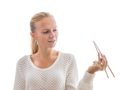 Young smilling happy smiling girl with chopsticks isolated on whiteの写真素材