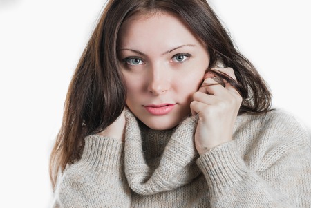 Portrait of young beautifull woman in big warm sweater isolated on whiteの写真素材