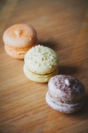 Three colourful macaroons on the wooden tableの写真素材