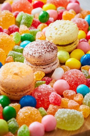 Colorful candies, macaroons and jujube on the wooden tableの写真素材