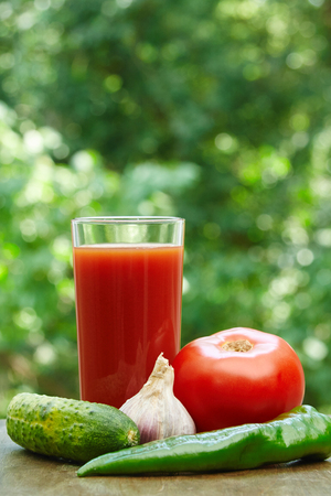 Composition  of fresh tomato, garlic, tomato juice, hot pepper and cucumber on the wooden tableの写真素材