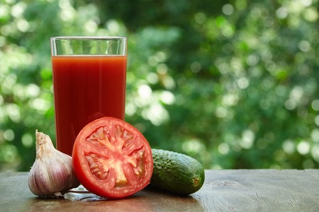 Composition  of tomato juice, cucumber and half of tomato on the wooden tableの写真素材