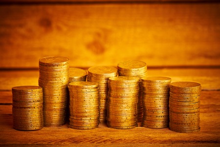 Piles of old coins on the wooden tableの写真素材