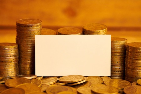 Dollar bills wrapped in jute rope, business card and piles of coinsの写真素材