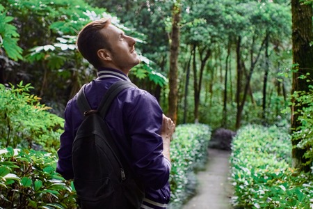 Man traveling in the forest with backpack