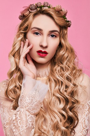 Fashion photo of young woman on pink background wearing gold diademの写真素材