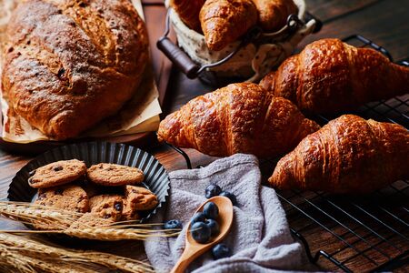Delicious pastry and wheat spikes on the wooden tableの写真素材