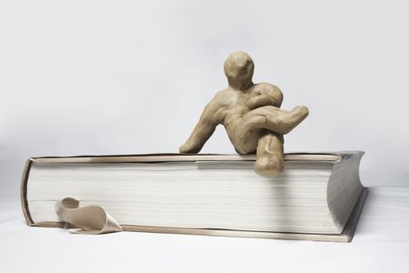 The plasticine person studies the book from the different partiesの写真素材
