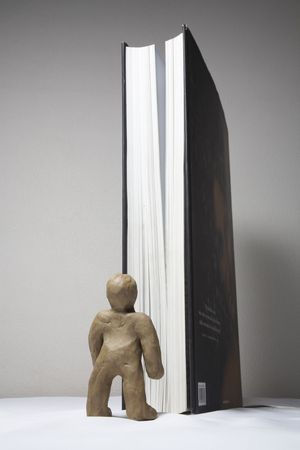 The plasticine person studies the book from the different partiesの写真素材