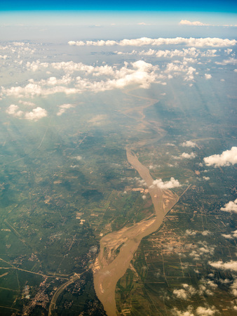 High angle view of farmland and buildings by the seaの写真素材