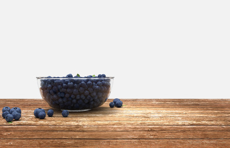 3D render. Glass bowl full of blueberries on wooden tableの写真素材