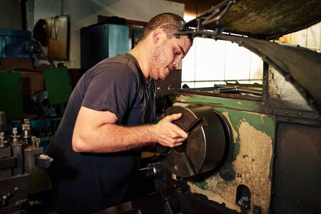 Mechanical Engineer Controlling Lathe Machine in Factory.