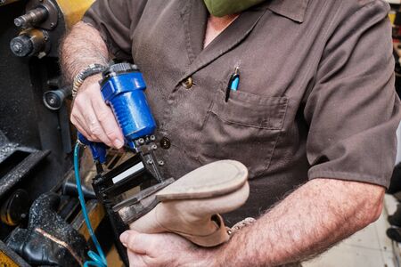 Shoemaker working on coronavirus days with maskの写真素材