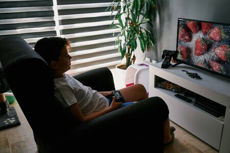 Child playing with the console at homeの写真素材