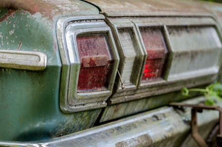 Detail of a rusty green car abandoned by the side of the roadの写真素材