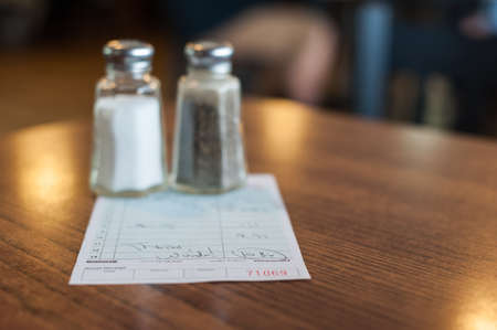 Salt and pepper shakers resting on top of the checkの写真素材