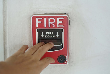 A hand was pulling down the fire call to fire alarm.の写真素材