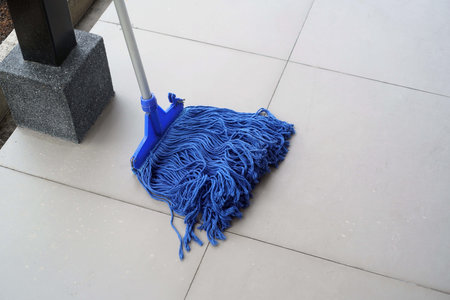 Blue mop on the tile floor, closeup of photo.の写真素材