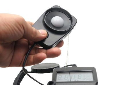 Close up a hand catching a light probe of a LUX meter for measurement.の写真素材