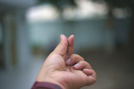 Hand of a man holding something with blur background, can be used as backgroundの写真素材