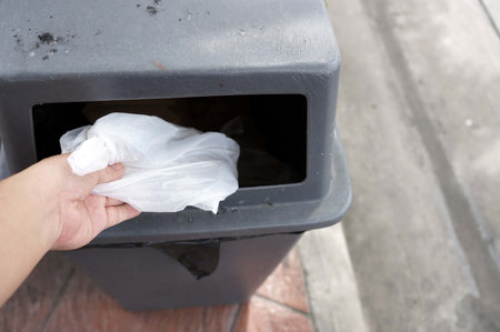 Hand throwing garbage in the trash can, trash can concept save environmentの写真素材