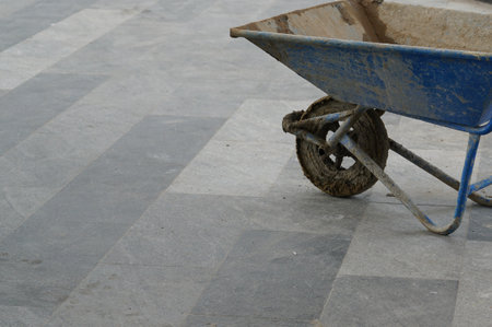 Wheelbarrow on cement floor in construction site.